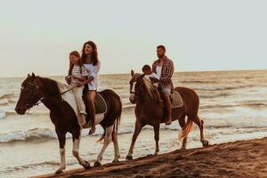 la famille passe du temps avec ses enfants tout en faisant de l'équitation ensemble sur une plage de sable. mise au point sélective photo