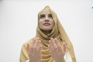 portrait de magnifique musulman femme dans à la mode robe avec hijab fabrication traditionnel prière à Dieu garde mains dans prier geste isolé sur blanc Contexte photo