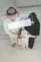 portrait de une Jeune content arabe musulman famille couple avec une fils dans traditionnel vêtements dépenses temps ensemble photo