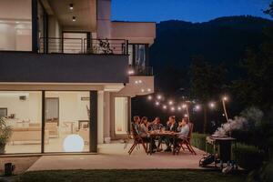 une groupe de Jeune diverse gens ayant dîner sur le terrasse de une moderne maison dans le soir. amusement pour copains et famille. fête de vacances, mariages avec barbecue. photo