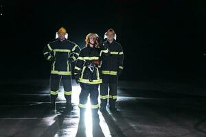 portrait de une groupe de sapeurs pompiers permanent et en marchant courageux et optimiste avec une femelle comme équipe chef. photo