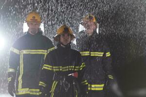 portrait de une groupe de sapeurs pompiers permanent et en marchant courageux et optimiste avec une femelle comme équipe chef. photo