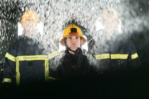 portrait de une groupe de sapeurs pompiers permanent et en marchant courageux et optimiste avec une femelle comme équipe chef. photo