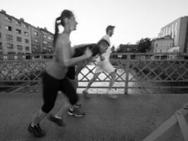 jeune couple faisant du jogging sur le pont de la ville photo