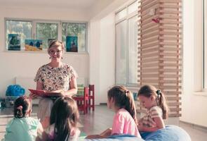 en train de lire temps dans élémentaire école ou Jardin d'enfants, prof en train de lire une livre à des gamins dans élémentaire école ou maternelle. sélectif concentrer photo