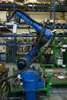 Le bras mécanique du robot de soudage automatique travaille dans l'usine moderne de pièces automobiles. photo