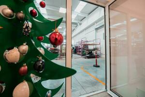 sapin de noël avec une guirlande au bureau. photo