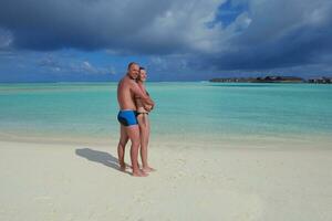 heureux jeune couple en vacances d'été s'amuser et se détendre à la plage photo