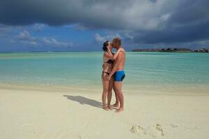 heureux jeune couple en vacances d'été s'amuser et se détendre à la plage photo