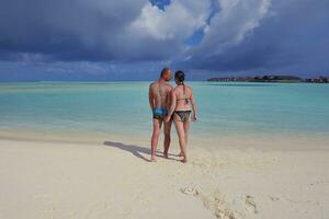 heureux jeune couple en vacances d'été s'amuser et se détendre à la plage photo