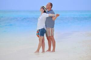 heureux jeune couple s'amuser sur la plage photo