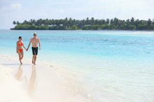 heureux jeune couple s'amuser sur la plage photo