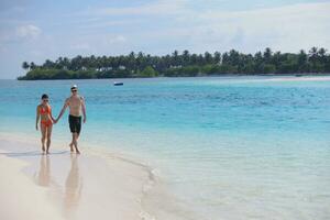 heureux jeune couple s'amuser sur la plage photo