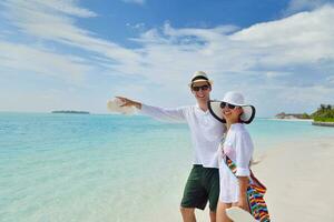 heureux jeune couple s'amuser sur la plage photo