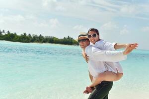 heureux jeune couple s'amuser sur la plage photo