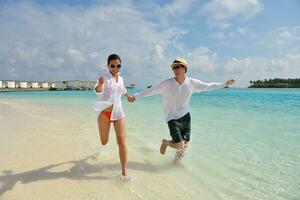 heureux jeune couple s'amuser sur la plage photo