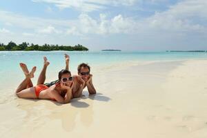 heureux jeune couple s'amuser sur la plage photo