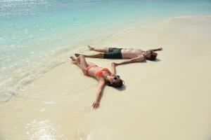 heureux jeune couple s'amuser sur la plage photo