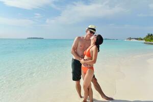 heureux jeune couple s'amuser sur la plage photo