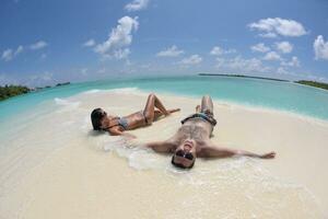 heureux jeune couple s'amuser sur la plage photo