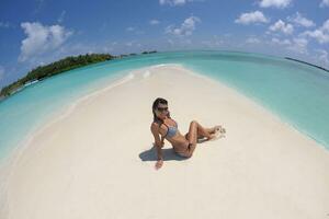 belle jeune femme sur la plage s'amuser et se détendre photo