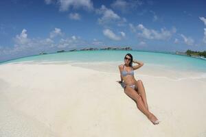 belle jeune femme sur la plage s'amuser et se détendre photo