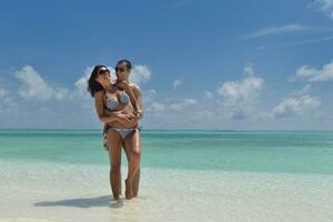 heureux jeune couple s'amuser sur la plage photo