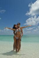 heureux jeune couple s'amuser sur la plage photo