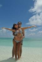 heureux jeune couple s'amuser sur la plage photo