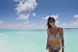 belle jeune femme sur la plage s'amuser et se détendre photo