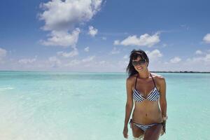 belle jeune femme sur la plage s'amuser et se détendre photo