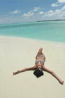 belle jeune femme sur la plage s'amuser et se détendre photo