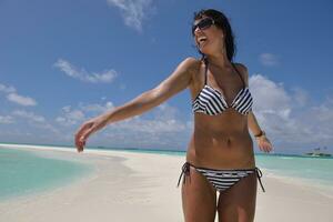 belle jeune femme sur la plage s'amuser et se détendre photo