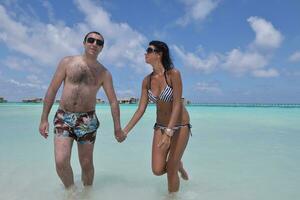 heureux jeune couple s'amuser sur la plage photo