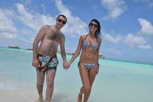 heureux jeune couple s'amuser sur la plage photo