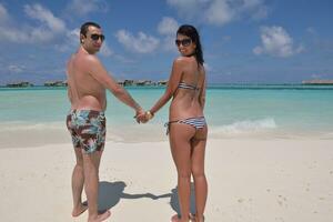 heureux jeune couple s'amuser sur la plage photo