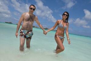 heureux jeune couple s'amuser sur la plage photo