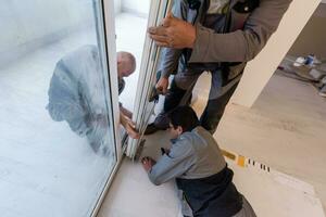 charpentiers installant une porte de balcon photo