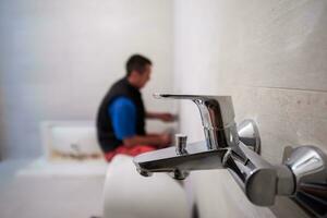 plombier professionnel travaillant dans une salle de bain photo