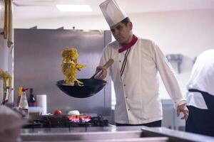 chef retournant les légumes au wok photo