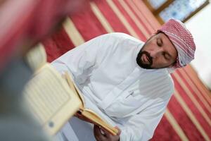deux musulmans dans la mosquée lisant le coran ensemble concept d'éducation islamique photo