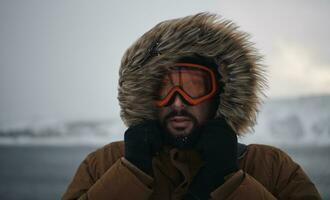 homme en hiver par temps orageux portant une veste de fourrure chaude photo