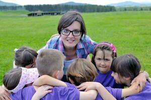 groupe d'enfants heureux avec professeur dans la nature photo