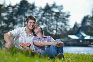 heureux jeune couple ayant un pique-nique en plein air photo