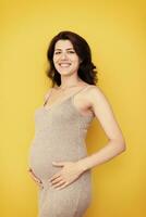 portrait de femme enceinte sur fond jaune photo