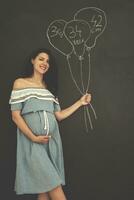 portrait de femme enceinte devant un tableau noir photo