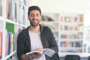 portrait d'étudiant en lisant un livre dans la bibliothèque de l'école photo