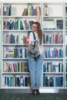 étudiante célèbre en sélectionnant un livre à lire dans la bibliothèque photo