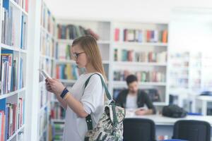 étudiante célèbre en sélectionnant un livre à lire dans la bibliothèque photo