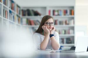 Étudiante étudier à la bibliothèque de l'école photo